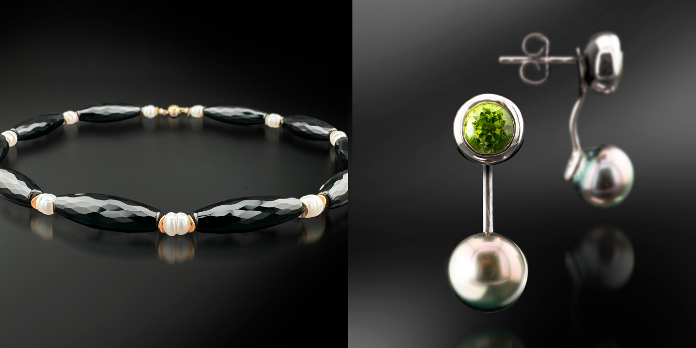 Eine Halskette aus schwarzem Stein mit Perlen und ein Ohrring mit grünen Steinen und Perlen.